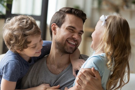 Haus-Familie-Wohnen-Serie-3-22 Überglücklicher junger Vater mit Sohn und Tochter